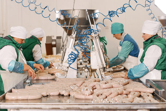 Women wrapping sausages at plant