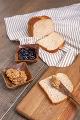 Fototapeta na wymiar Peanut Butter, Grape Jelly, Loaf Bread Gathered to Make Sandwiches