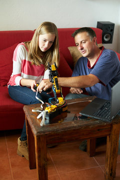 Father is teaching his daughter robotics and programming