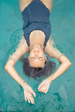 Sexy woman in hat chilling in the swimming pool