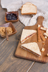 Peanut Butter and Jelly Sandwich on Cutting Board on Wooden Table
