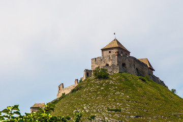 Fototapeta na wymiar Ancient knight's castle on a hill (Hungary) on a background of gloomy sky