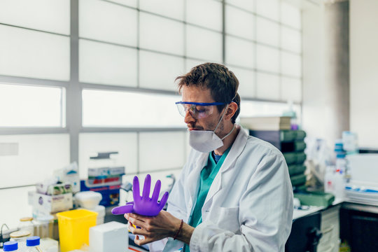 Biologist puttiing on gloves in the Laboratory