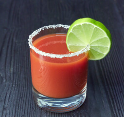 cocktail Bloody Mary or Caesar with lemon and lime on a black wood background