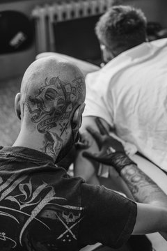 Tattoo artist drawing on client's skin