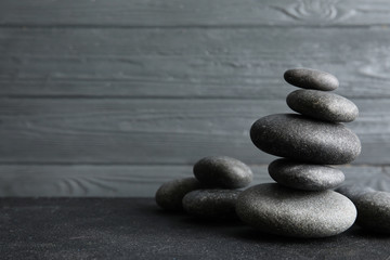 Stacked zen stones on table against wooden background. Space for text