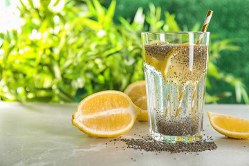 Glass of water with chia seeds and lemon on table. Space for text
