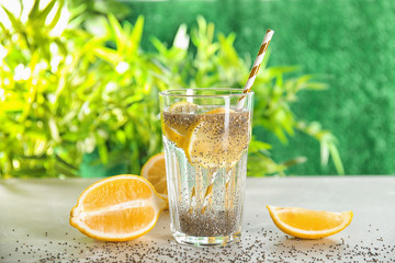 Glass of water with chia seeds and lemon on table