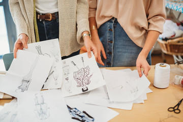 Two young female fashion designers working together at the design studio