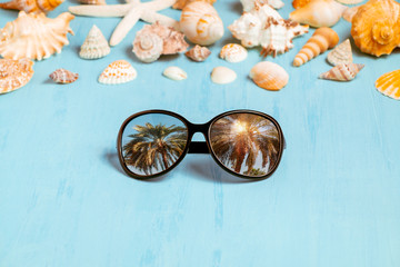 Blue sea background with sunglasses and seashells, summer holiday and vacation time concept
