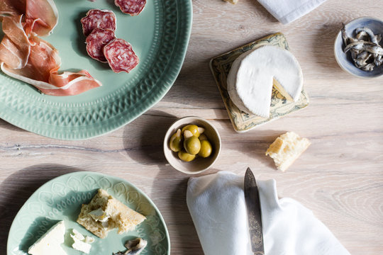 A european inspired lunch of baguette, cheese, charcuterie, olives and anchovies.