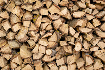 dry chopped firewood logs in a pile, ready for winter