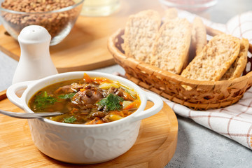 Lentil soup with chicken in a white bowl on a wooden board