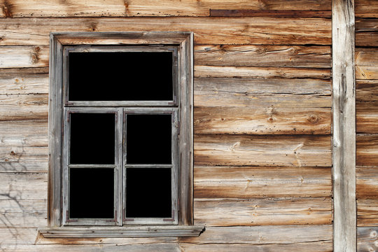 Rustic window in wooden village cottage house. Grunge brown wood wall.