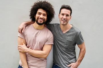 Good-looking happy men in casual t-shirts smiling at camera.