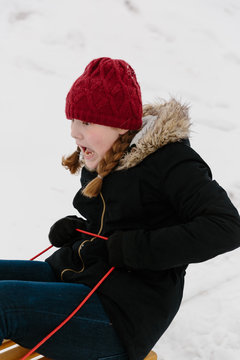 Girl screaming while riding a sled