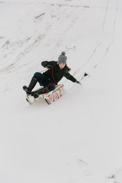 Boy riding a sled downhill