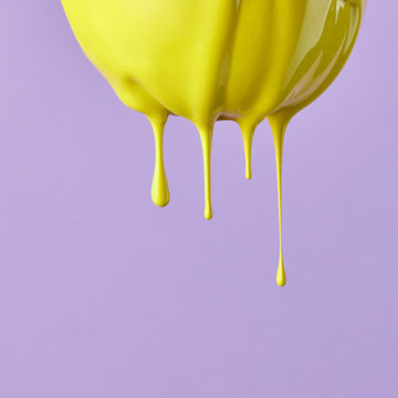 Lemon painted with yellow paint on a purple background