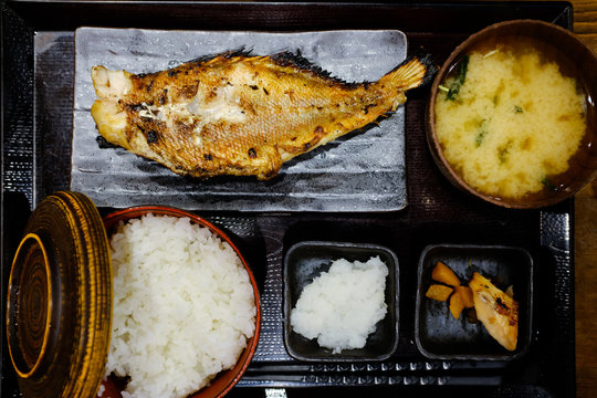 Traditional Japanese food with grilled fish, side dishes and miso soup