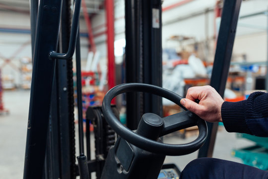 Man driving a forklift truck inside factory