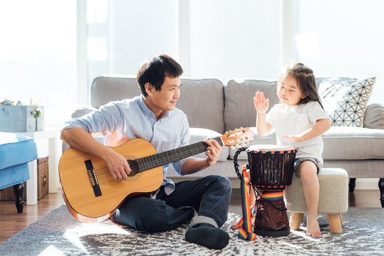 Father and daughter playing musical instruments