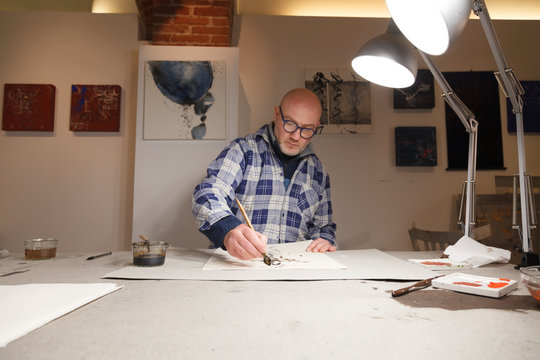 portrait of a Master Calligrapher making artworks in his atelier