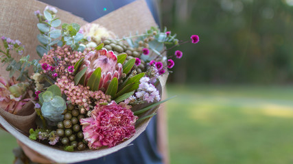 man holding bouquet of Australian native flowers with copy space