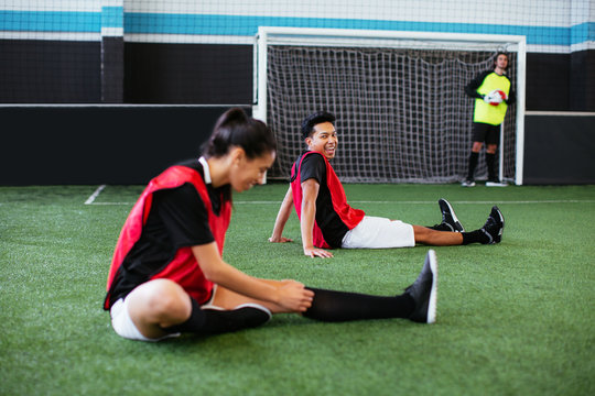 Soccer players stretching in football field. - Powered by Adobe