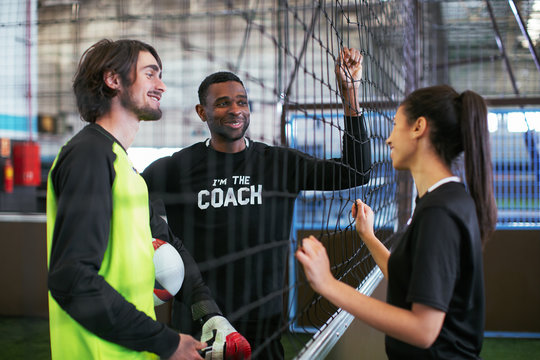 Soccer players talking in indoor football field.