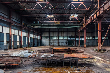 Abandoned industrial building with old rusty bridge crane and metal constructions