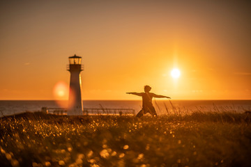 Position de yoga près du phare du Borgot aux Iles de la Madeleine © Claude