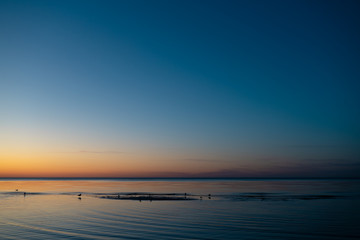 Vivid amazing sunset in Baltic States - Dusk in the sea with horizon illuminates by the sun