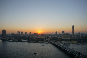 Cairo, Egypt: Cairo Tower and the Qasr el Nile Bridge at sunset. On Gezira Island in the River Nile, the tower is the tallest structure in Egypt.