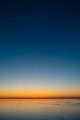 Naklejka na ściany i meble Vivid amazing sunset in Baltic States - Dusk in the sea with horizon illuminates by the sun