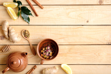 Flat lay composition of herbal tea, tea accessories, honey, spoon of dried tea, plant leaves, ginger root, lemon. Border frame, view from above, alternative medicine concept.
