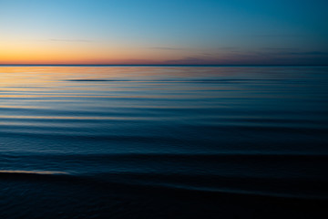 Vivid amazing sunset in Baltic States - Dusk in the sea with horizon illuminates by the sun