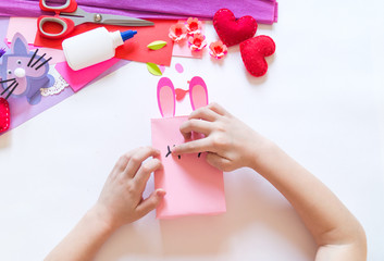Child hands making a box rabbit. Holiday Easter light. Material for creative. hand people