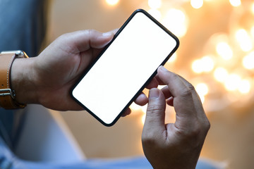 Closeup male hands using mobile smartphone at blurred night background.