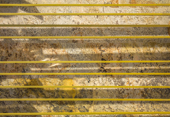 horizontal yellow lines on a background of white gray brown spotted granite with shadows. rough surface texture