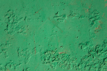 old dirty damaged green concrete wall with scratches and black holes. rough surface texture