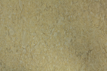 yellow surface of white stones of various shapes and sizes in cement. rough texture
