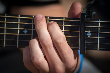 Man fingering a chord on a guitar
