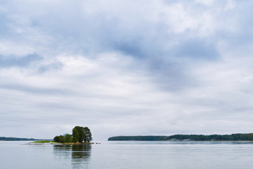 A small island with cloudy sky in the background