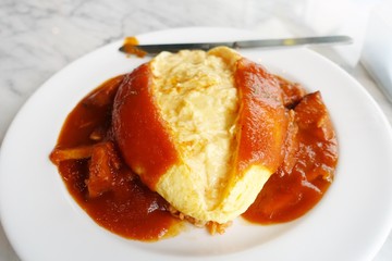 Omelet wrapping rice, topping with tomato sauce, hot from the kitchen,a big dish for your breakfast or lunch, full dish