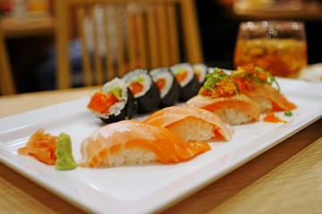 Salmon sushi on top with rice, side dish is a rice with seaweed wrap, main dish for lunch or your dinner, delicious food from good ingredient, relaxing after work.