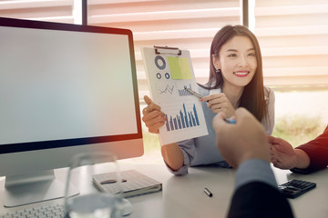 Businesswoman showing graphs chart to teamwork at meeting room.