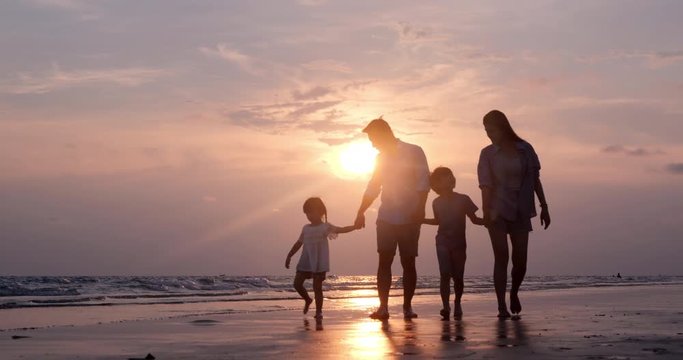SLOW MOTION, Silhouetted Asian family walking together at Beach. Family, Holiday and Travel concept.