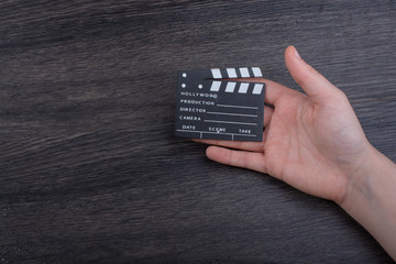 Hand holding a little movie  clapper in hand