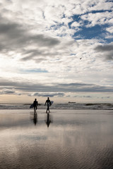 Two male surfers walking into the sea