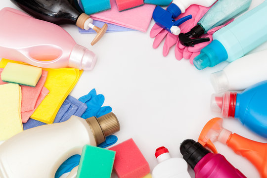 Cleaning equipment on light background. Bottles with detergent and cleaning tools. Colorful cleaning products. Washing, cleaning concept. 
